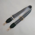 Close-up of black and white geometric woven bag strap with golden lobster clasps - Dark Green Strap with Green Leather