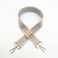Detail of wide woven bag strap with brown geometric chevron patterns and gold metal hooks - Khaki