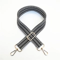 Detail of black and white woven bag strap with golden metal clasp and adjustable buckle - Black