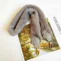 Close-up of fluffy grey faux fur shoulder strap with gold metal lobster clasps on magazine - Gray