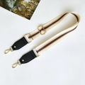 Detail of adjustable cream strap with red-green stripes and gold metal hardware - Beige with Black Leather