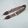 Close-up of adjustable ethnic pattern woven strap with gold lobster clasps and leather trim - Brown