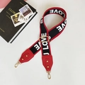 Detail of red and black woven bag strap with white LOVE lettering and gold metal clips - Letter Red