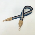 Detail of adjustable woven wide bag strap with navy stripes and light gold metal hardware - Blue Striped Khaki
