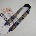 Close-up of ethnic geometric weave shoulder strap with navy leather and gold hardware - Blue