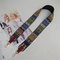 Close-up of ethnic style woven bag strap with red leather ends and gold metal buckles - Burgundy