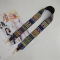 Close-up of ethnic style woven strap with geometric patterns and golden metal clasps - Brown