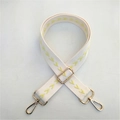 Gros plan sur la bandoulière réglable en coton avec motif chevron jaune et crochets dorés - Blanc Cassé