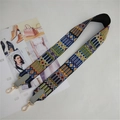 Close-up of ethnic style embroidered bag strap with geometric patterns and gold lobster hooks - Gray
