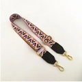 Detail of colorful geometric woven strap with gold metal buckles and leather ends - Pink (Black Trim)