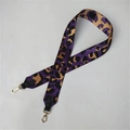 Détail d'une bandoulière tissée léopard avec attaches en cuir noir et crochets dorés - Violet