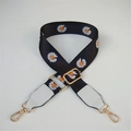 Close-up of adjustable black daisy print bag strap with gold lobster clasps and white leather - Black Strap With White Leather