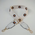 Detail of cream fabric strap with navy daisy print and polished gold metal hardware - White/Black Flower With White Leather