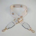 Detail of adjustable off-white canvas strap with blue daisy print and gold hardware - White/Orange Flower With White Leather
