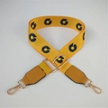 Detalle de la correa ajustable de nailon amarillo con margaritas y ganchos dorados - Correa amarilla con cuero amarillo