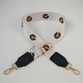 Detalle de la correa ajustable con diseño de margaritas y mosquetones metálicos dorados - Flor blanca/negra con cuero negro