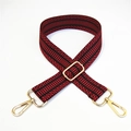 Detail of red and black geometric woven bag strap with polished gold metal buckles - Red