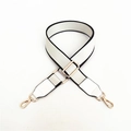 Detail of adjustable off-white woven bag strap with black edges and gold metal hardware - Silver Clasp / White