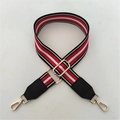 Detail view of the red and white striped wide bag strap with golden lobster clasps - Red Strap + Black Leather