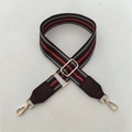 Detail of red and green striped woven strap with dark brown leather ends and gold metal clips - Green Strap + Coffee Leather