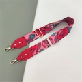 Detail view of pink wide canvas bag strap with red floral pattern and golden metal buckles - Rose Floral + Red Leather