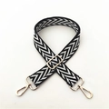 Detail of adjustable black and white herringbone patterned bag strap with gold metal buckles - Black