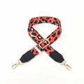 Close-up of leopard print canvas bag strap with golden metal hooks and buckles - Orange
