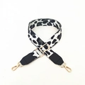Detail eines verstellbaren Leopard-Taschenriemens mit goldenen Karabinern und Lederenden - Schwarz