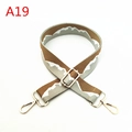 Close-up of adjustable woven shoulder strap with brown wave pattern and gold metal clasps - A19