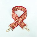 Detail eines roten Jacquard-Taschenriemens mit Wellenmuster und goldenen Metallhaken - Silberverschluss / Rot