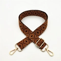 Detail of adjustable woven bag strap with geometric orange and black pattern and gold buckles - Brown