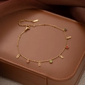 Detailed macro view of gold infinity charms and colorful gems on an S.STEEL anklet chain - Infinity