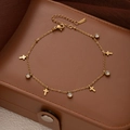 Detail of gold titanium steel anklet with cross charms and zircons on leather - Cross