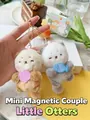 Macro detail of magnetic plush otter keychains with soft fur and hand-held sea shells - Otter