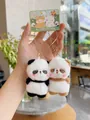 Close-up of plush bear keychains with magnetic attraction and embroidery details - Panda