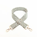 Détail de la bandoulière brodée à motifs géométriques avec mousquetons dorés - Vert matcha
