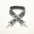 Close-up of ethnic blue floral embroidery on adjustable wide grey shoulder strap with gold clips - Size 58