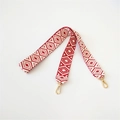 Detail eines rot-weißen gewebten Boho-Taschenriemens mit goldenen Karabinerhaken - Rot