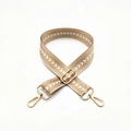 Detail of camel woven bag strap with white arrow pattern and golden metal hardware - Khaki