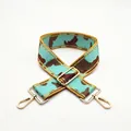 Macro detail of adjustable camouflage canvas strap with gold metal buckle and swivel hooks - US 13