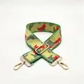 Detailed macro view of wide camouflage canvas bag strap with gold metal hardware - US 14