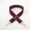 Detail view of red and black houndstooth pattern bag strap with golden metal hardware - Burgundy