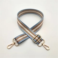 Détail de la bandoulière en tissu rayé bleu clair et blanc avec des fils dorés brillants - Rose bonbon