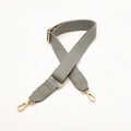 Macro shot of grey adjustable PU leather bag strap with gold metal hooks and stitching - Gray