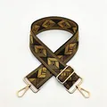 Close-up of black and gold geometric woven bag strap with golden lobster clasps - a6 Light Yellow