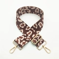 Detail eines verstellbaren Leopard-Taschenriemens mit goldenen Karabinern und Schiebeschnalle - Silberverschluss / Kontrast-Kuhmuster Braun
