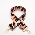 Detail eines verstellbaren Camo-Taschenriemens in Orange und Schwarz mit Goldhaken - Silberverschluss / Kontrast-Kuhmuster Orange
