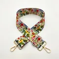Gros plan d'une bandoulière en toile florale avec mousquetons dorés et boucle de réglage - Fermoir en Argent / Étoile à Cinq Branches
