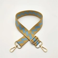 Detail eines gelb-blauen gewebten Taschengurt mit goldenen Metallhaken-Verschlüssen - Gelb