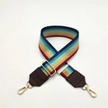 Close-up of colorful striped bag strap with gold metal hooks and brown leather details - Brown
